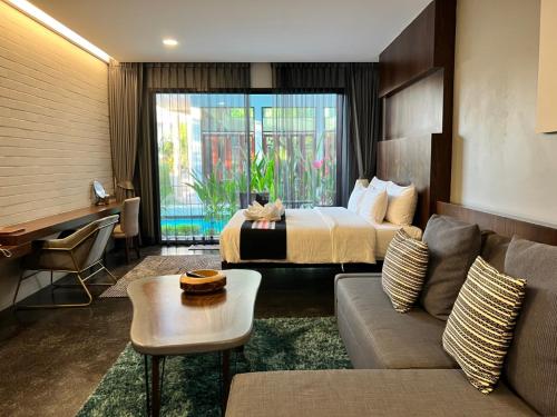 清莱NAI YA Hotel -SHA Extra Plus的酒店客房,配有床和沙发