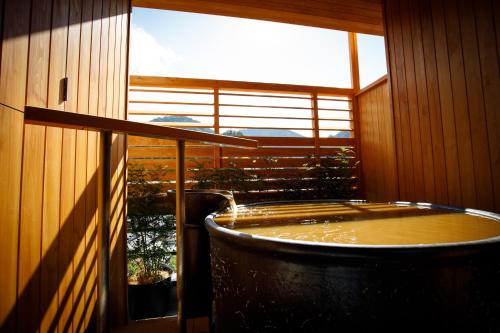 神户中之坊瑞苑日式旅馆（仅限成人入住）的带大窗户的客房内的热水浴池
