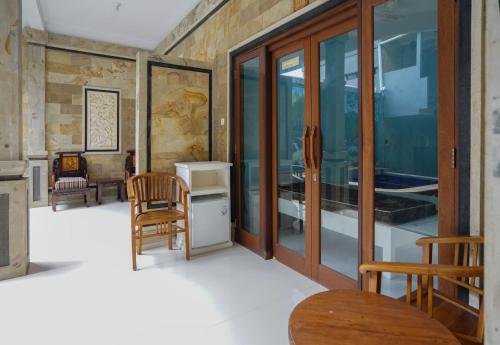 图兰奔AERO氧程巴厘岛潜水度假酒店的一间设有玻璃门和桌椅的房间