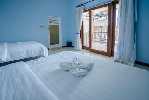 图兰奔AERO氧程巴厘岛潜水度假酒店的一间卧室配有两张床和白色毛巾。