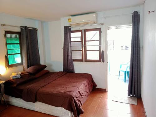 曼谷年轻美丽旅馆的一间卧室设有一张床和一个大窗户