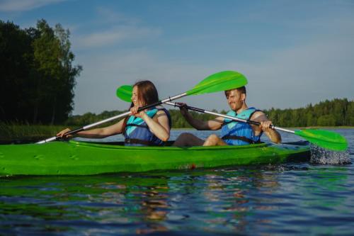 Lielie UnguriAimasas Camping的两人在水上的绿色皮艇上