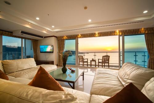 芭东海滩Patongtower Duplex Seaview4BR2902的客厅配有白色家具,享有海景。