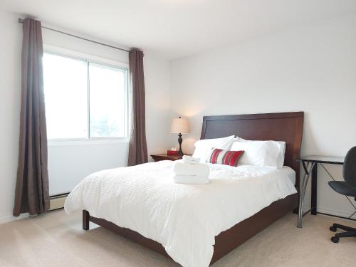 基洛纳Tranquil Retreat Spacious 2-Bedroom on a Serene Acreage的卧室配有白色的床和窗户