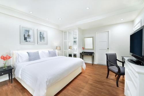曼谷齐隆中心点酒店 的白色卧室设有一张大床和电视。