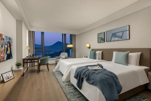 杭州杭州馨乐庭青山湖公寓酒店的一间大卧室,配有一张大床和一张书桌