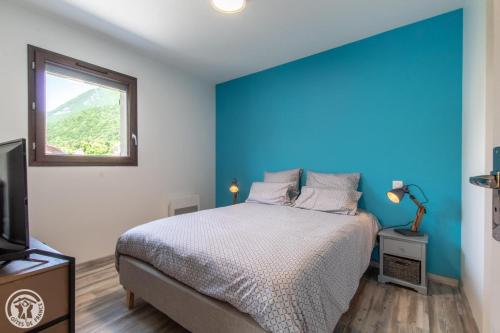 杜萨尔Gite Annecy 101 - Au royaume des Castors - Appt 101的蓝色的卧室设有床和窗户