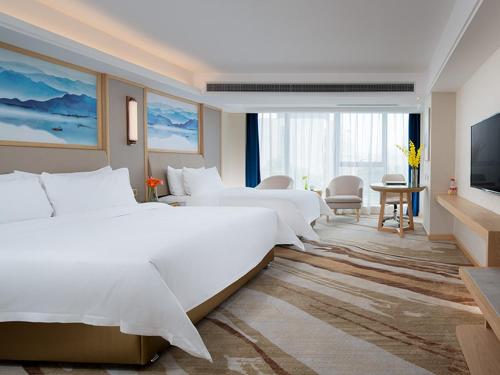 宝安维也纳国际酒店深圳国际会展中心南门店的酒店客房设有两张床和电视。