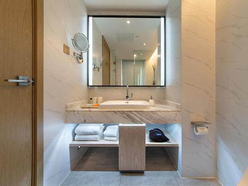 昆明凯里亚德酒店(昆明高新区吾悦广场店)的一间带水槽和大镜子的浴室