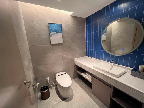 晋江凯里亚德酒店(泉州晋江国际机场店)的一间带卫生间、水槽和镜子的浴室