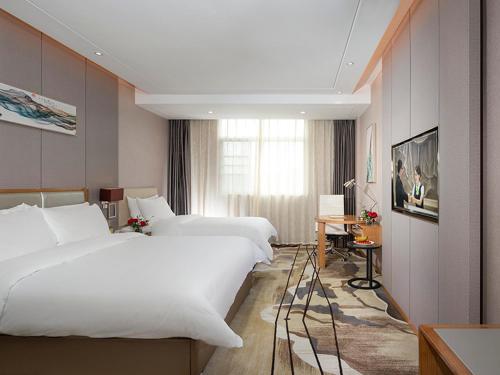 Longnan维也纳国际酒店赣州龙南迎宾大道店的酒店客房设有两张床和窗户。