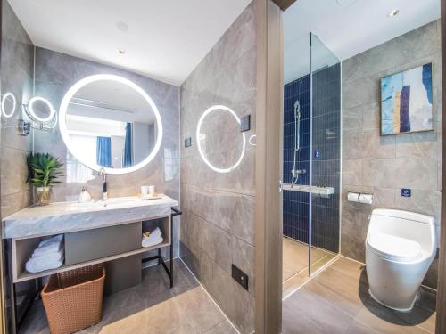 秦皇岛凯里亚德酒店秦皇岛南戴河店的一间带水槽、卫生间和镜子的浴室