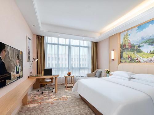 丹阳维也纳酒店江苏丹阳眼镜城高铁站大泊店的卧室配有一张白色大床和一张书桌