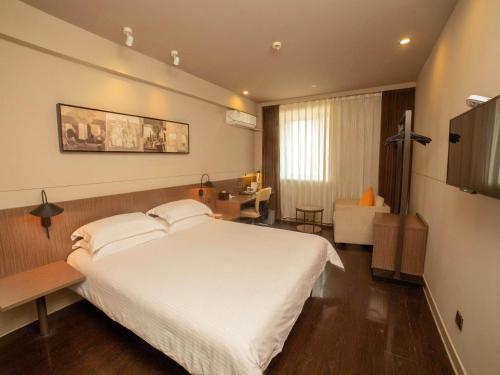 扬州锦江之星品尚(扬州瘦西湖四望亭路店)的卧室配有一张白色大床和一张书桌