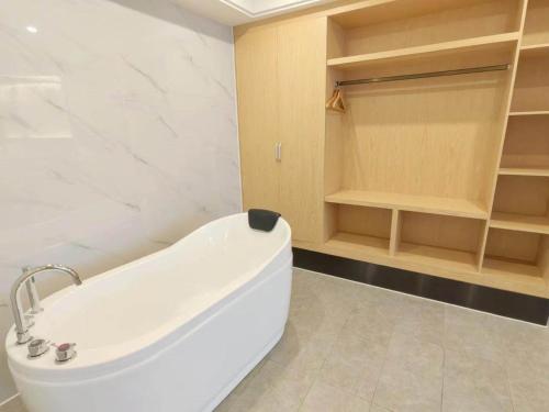都昌凯里亚德酒店(都昌步行街店)的带架子的浴室内的白色浴缸
