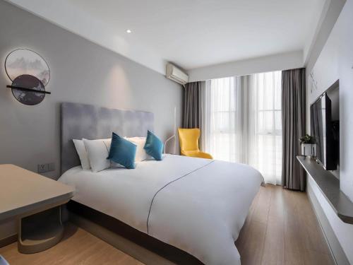 Jiangning白玉兰南京航空航天大学胜太西路酒店的酒店客房设有一张白色大床和一张书桌