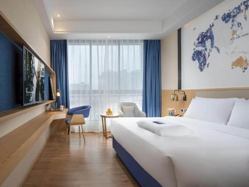 汉中凯里亚德酒店(汉中高铁站店)的一间酒店客房,设有一张大床和一个大窗户