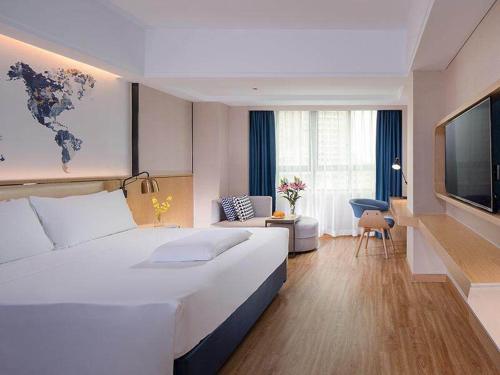 海口凯里亚德酒店(海口保税区店)的酒店客房设有一张大床和一台电视。