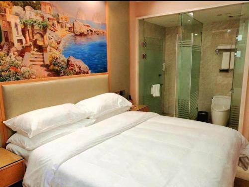 瑞安维也纳国际酒店浙江温州瑞安塘下店的卧室配有一张白色大床和一幅画