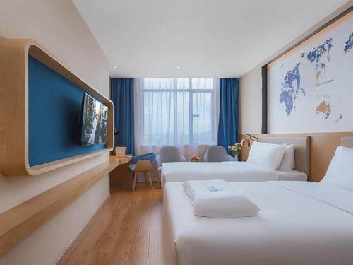 博罗凯里亚德酒店(博罗龙溪店)的酒店客房设有两张床和一台平面电视。