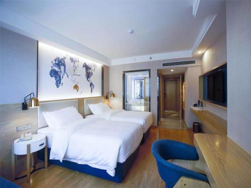 长沙凯里亚德酒店(长沙湘雅店)的一间酒店客房,设有两张床和电视