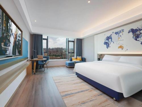 晋江凯里亚德酒店(泉州晋江国际机场店)的酒店客房设有一张床,墙上挂有地图