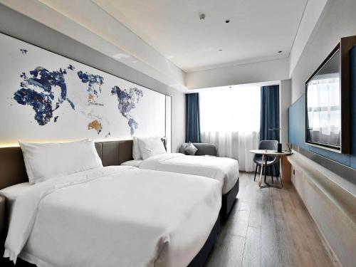 南昌凯里亚德酒店(南昌象湖金沙大道店)的两张位于酒店客房的床,墙上有地图