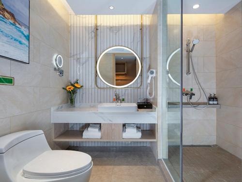 重庆维也纳国际酒店重庆北站店的一间带卫生间、水槽和镜子的浴室