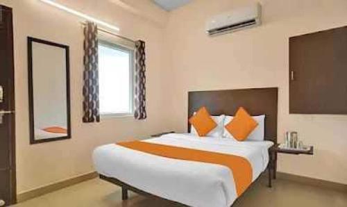 钦奈OYO Flagship ELEGANT RESIDENCY的一间卧室配有一张带橙色和白色枕头的大床