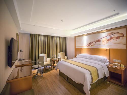 哈尔滨维也纳酒店哈尔滨哈西高铁万达广场店的酒店客房设有一张大床和一台电视。