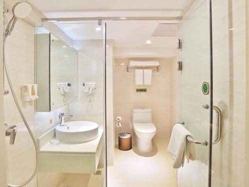 哈尔滨维也纳酒店哈尔滨哈西高铁万达广场店的浴室配有卫生间、盥洗盆和淋浴。
