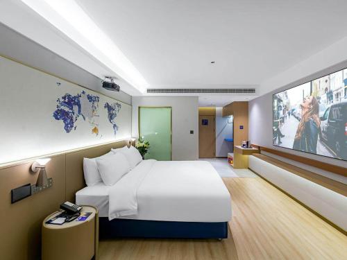 九江凯里亚德酒店(九江快乐城店)的酒店客房设有一张大床和一台电视机。