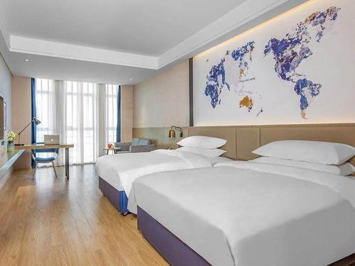 博罗凯里亚德酒店(惠州博罗园洲店)的酒店客房设有两张床,墙上挂有地图。