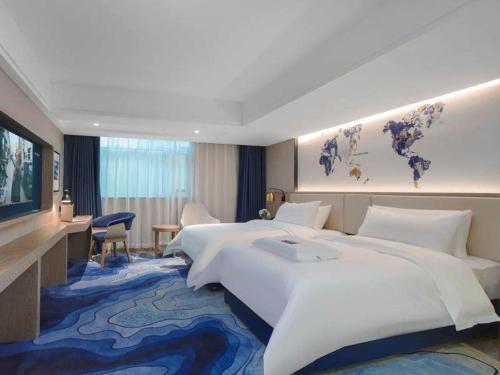 宝安凯里亚德酒店(深圳光明圳美地铁站店)的大型酒店客房设有一张大床和一张书桌