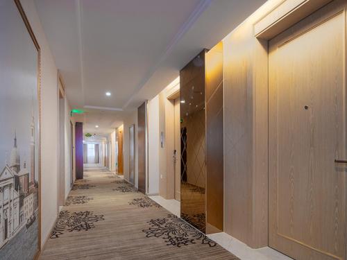无锡维也纳国际酒店江苏无锡太湖博览中心店的走廊上设有木地板和走廊上的四面 ⁇ 