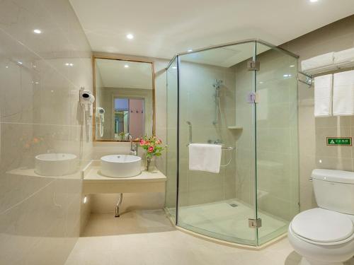 牡丹江维也纳智好酒店牡丹江火车站步行街店的一间带玻璃淋浴和卫生间的浴室