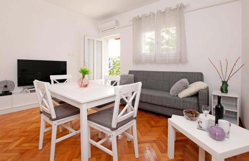 尼亚卢卡Apartman Žuvela的客厅配有白色桌子和沙发