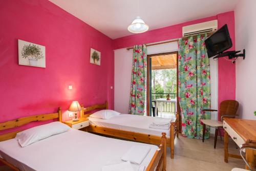 康托卡利Joanna Apartments的配有粉红色墙壁的客房内的两张床