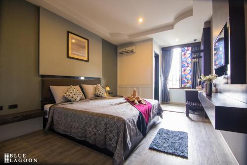 清莱Blue Lagoon Hotel的酒店客房设有床和窗户。