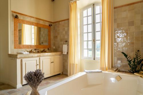 洛尔格Château les Crostes的带浴缸、水槽和镜子的浴室