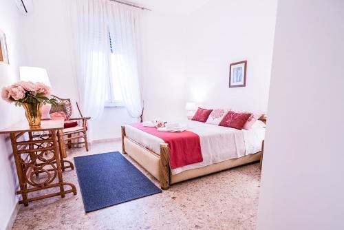奥尔比亚Liguria Garden的一间卧室配有一张床和一张花瓶桌子