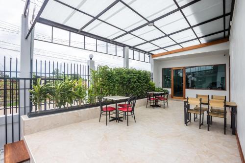 Ban Tao PunTonsoi Hathairat的一个带桌椅的庭院和玻璃天花板