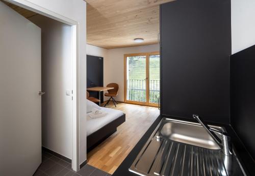 AussersiggamSimotel的一个带水槽的厨房和一张位于客房内的床