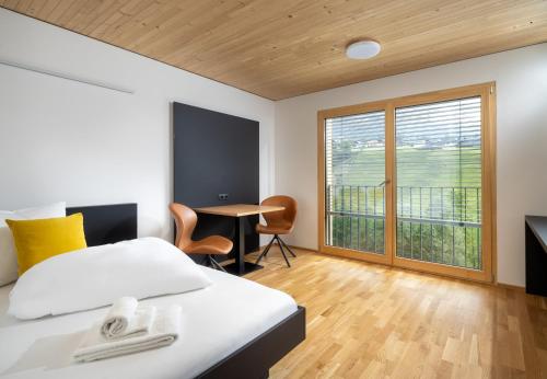AussersiggamSimotel的一间卧室配有一张床、一张书桌和一个窗户。