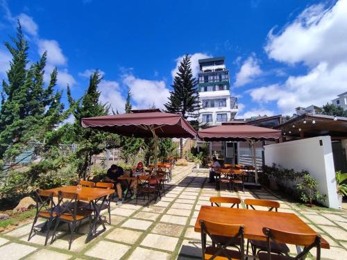大叻GREENECO DA LAT HOTEL - Khách sạn Green Eco Đà Lạt的一座配有桌椅的庭院和一座建筑