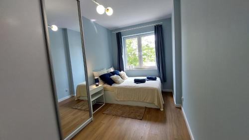 姆瓦瓦Apartament Mariacka的镜子,房间带床和窗户