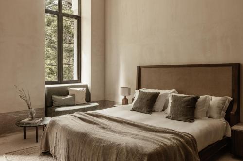 瓦尔特西尼科MANNA的一间卧室配有一张大床和一把椅子