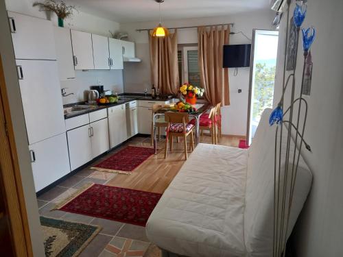 奥米沙利D,apartman的厨房配有白色橱柜和桌椅