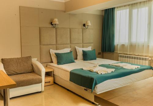 瓦尔纳Vemara City Apart Hotel的配有一张床和一把椅子的酒店客房