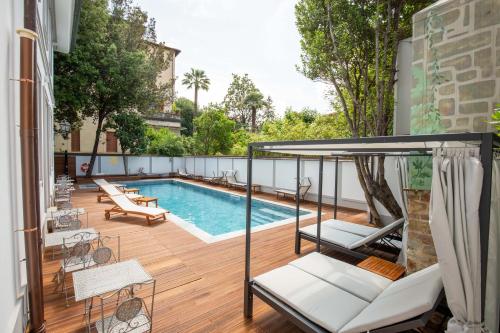 佛罗伦萨Villa Tortorelli的后院设有游泳池和带秋千的甲板